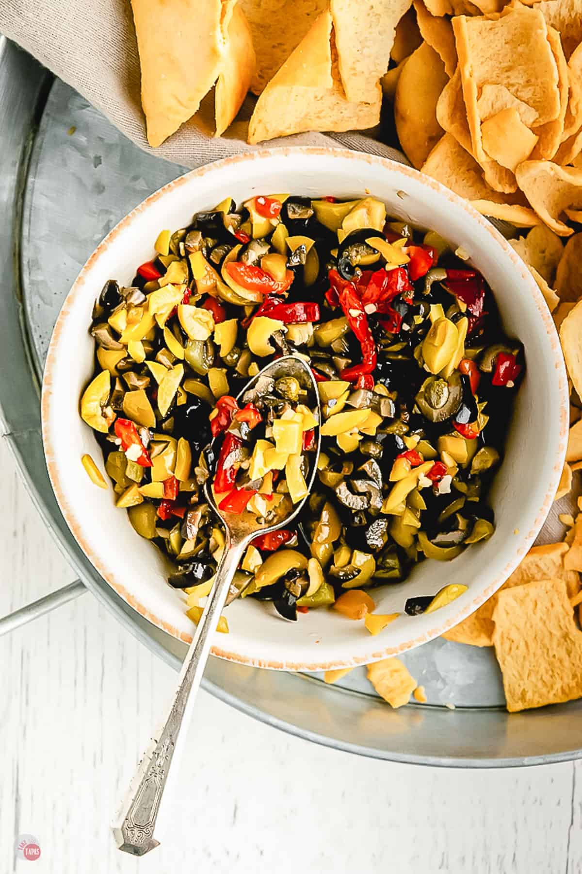 overhead of bowl of olives and spoon