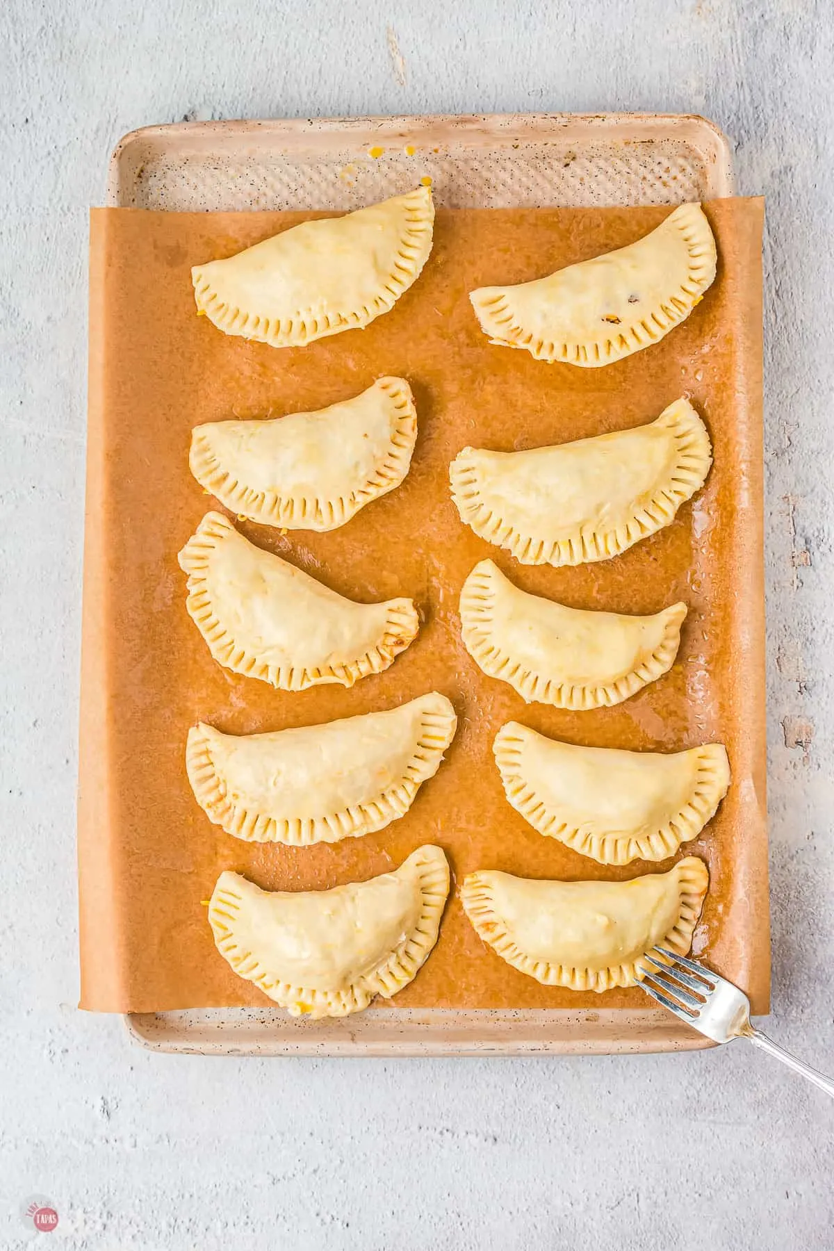 unbaked empanadas on a baking sheet