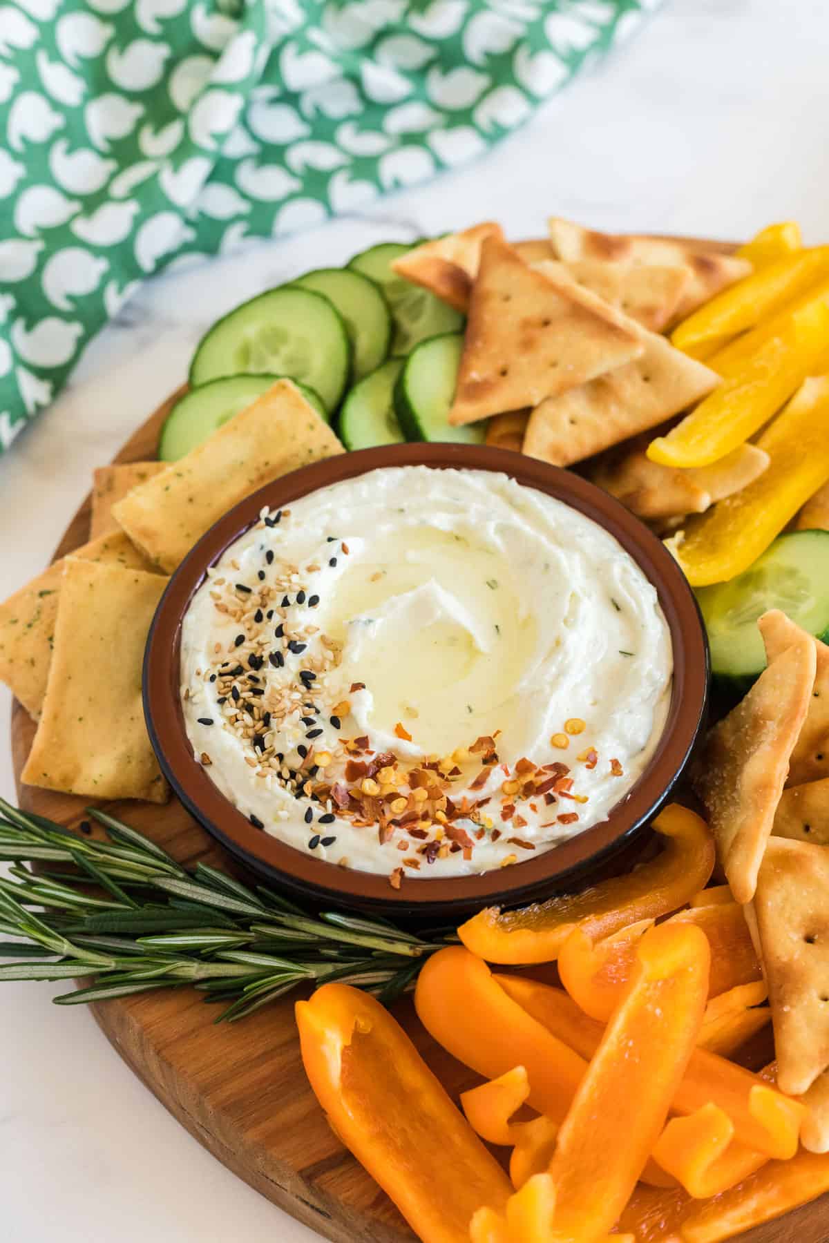 bowl of feta dip with veggies on a wood platter