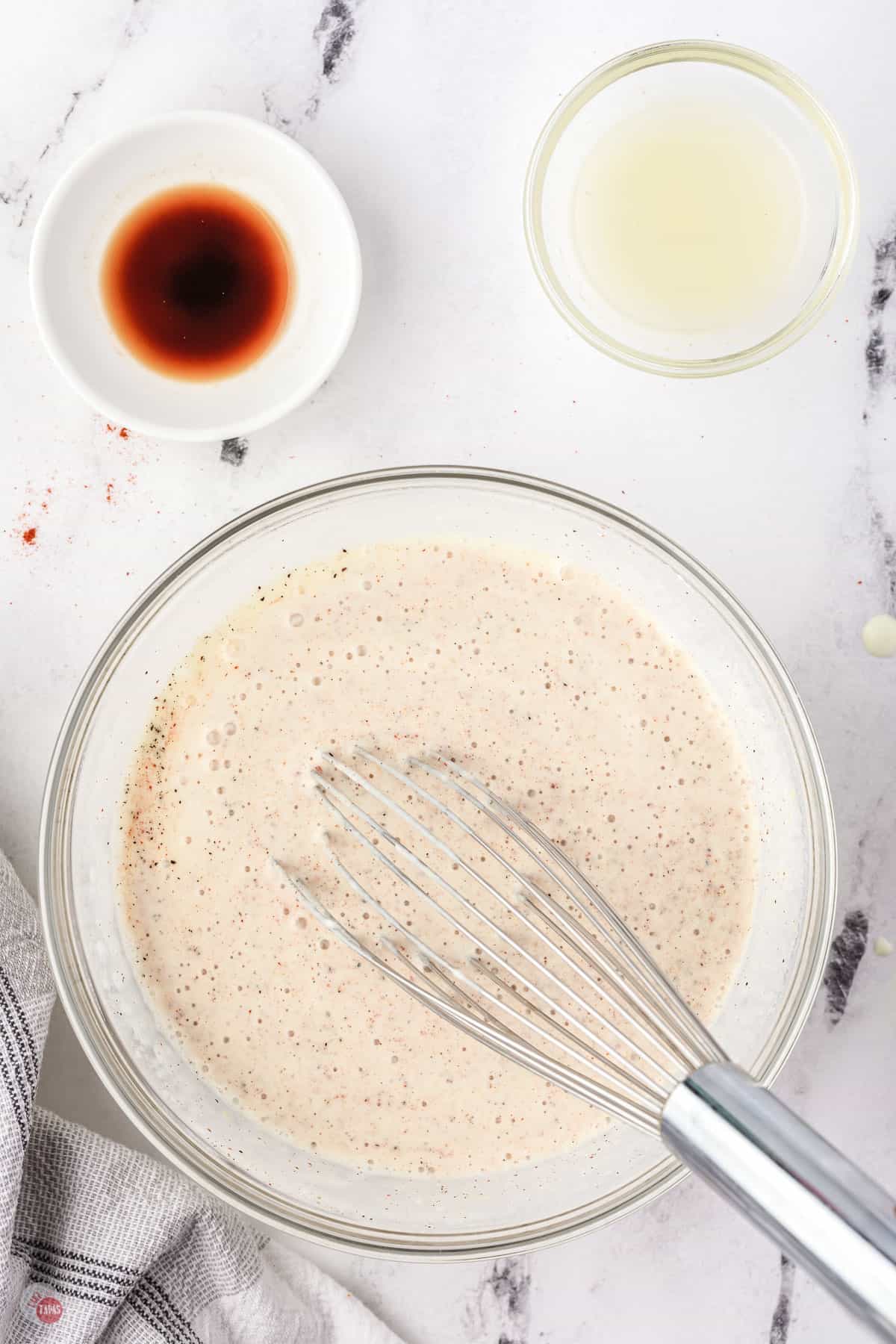 alabama white sauce in a bowl with a whisk