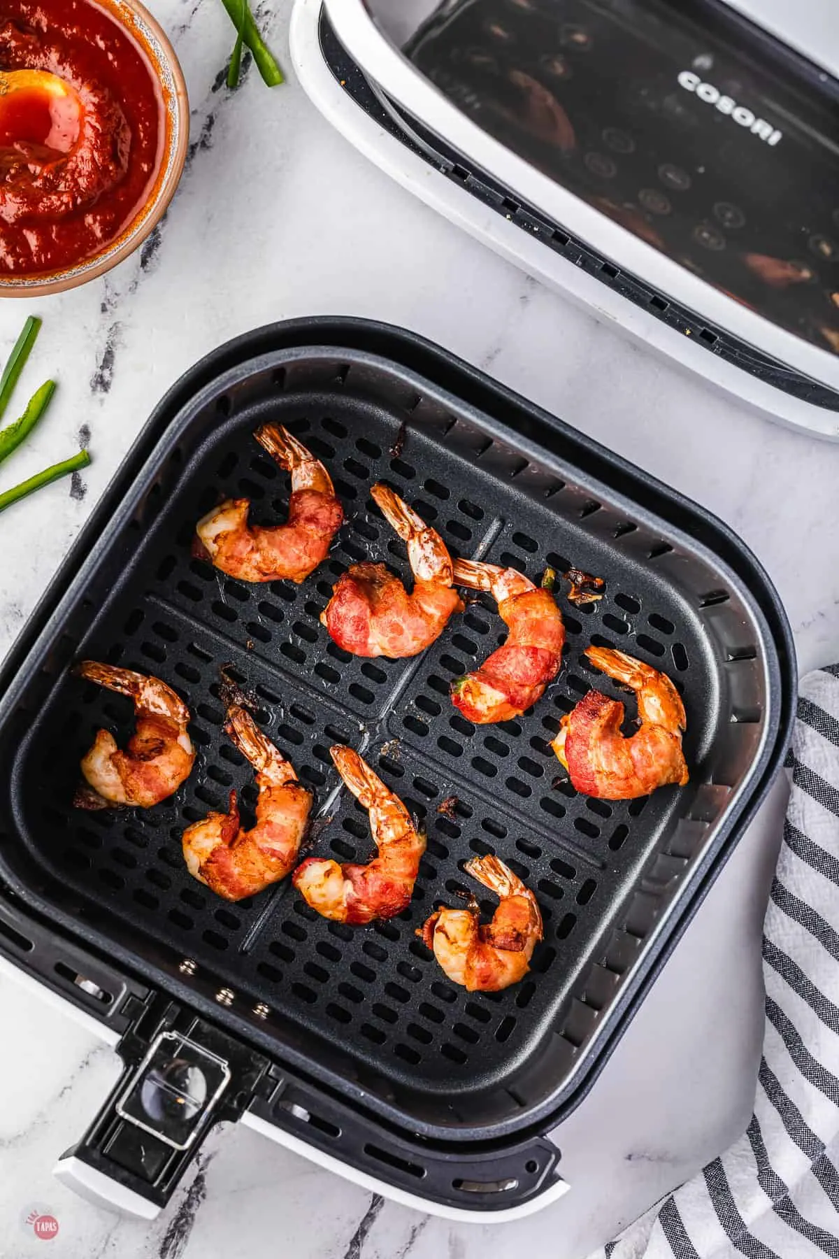 cooked shrimp in an air fryer basket