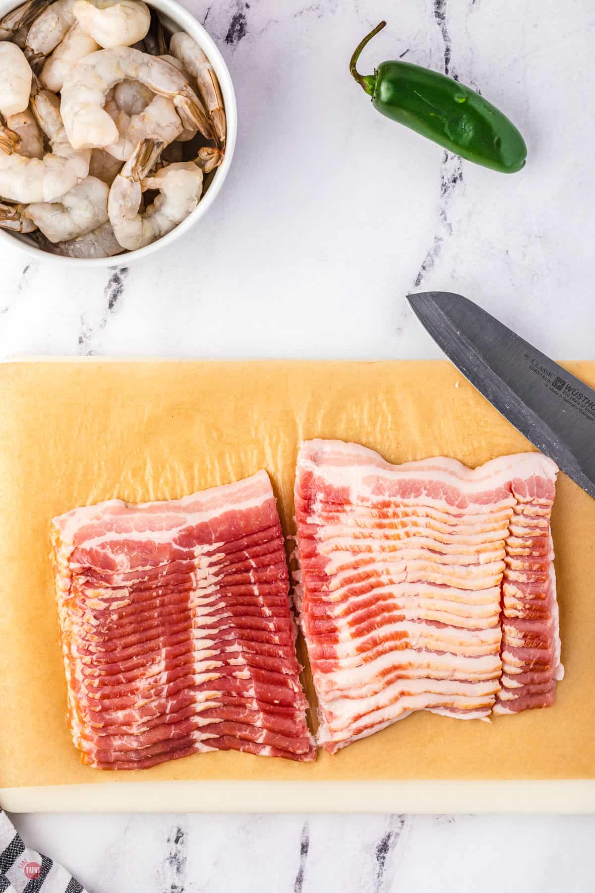 cut bacon on a board with a knife