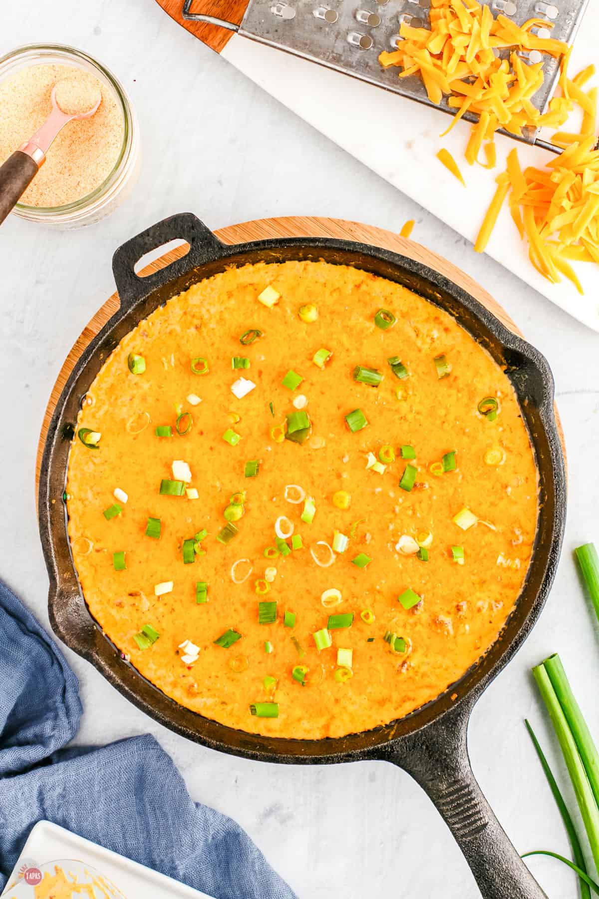 hamburger dip in a pan with green onions on top
