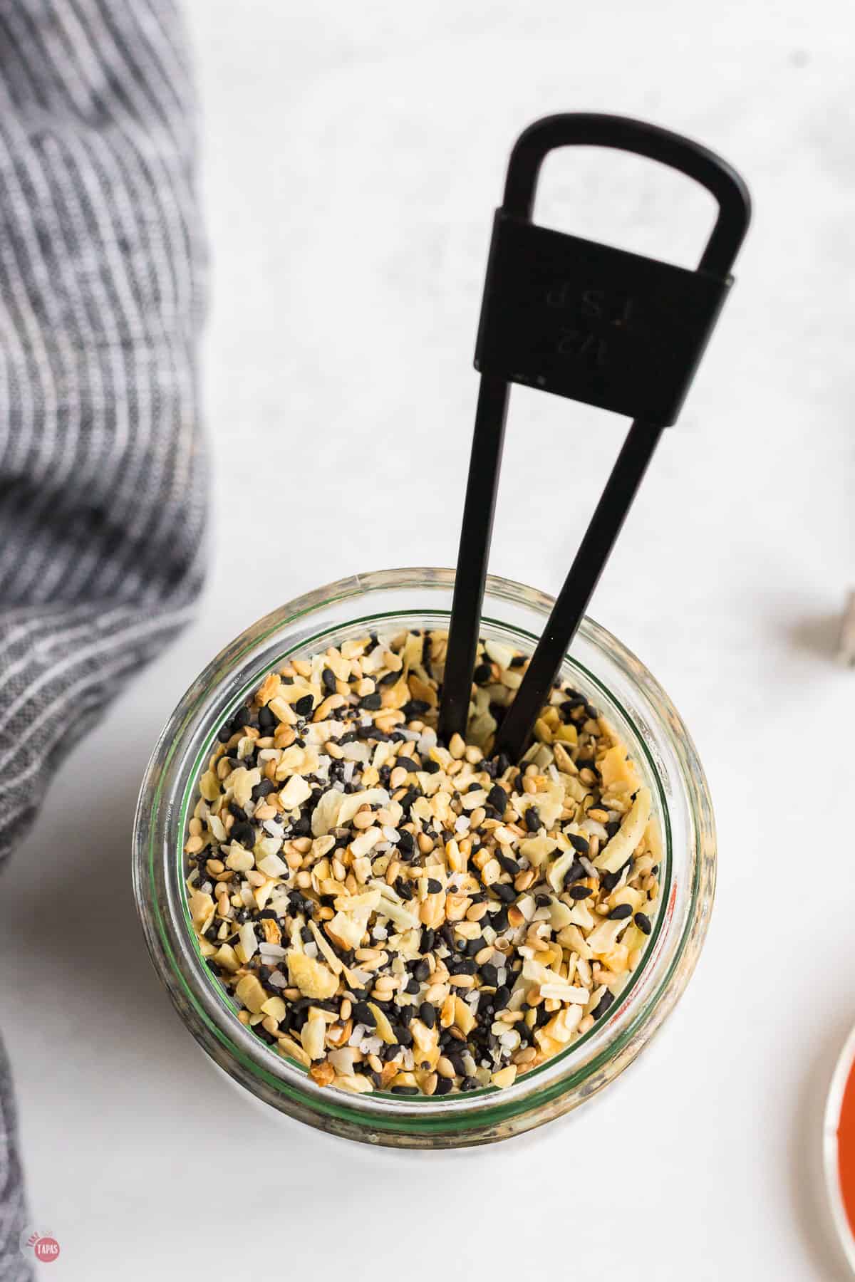 jar of seasoning with a black measuring spoon