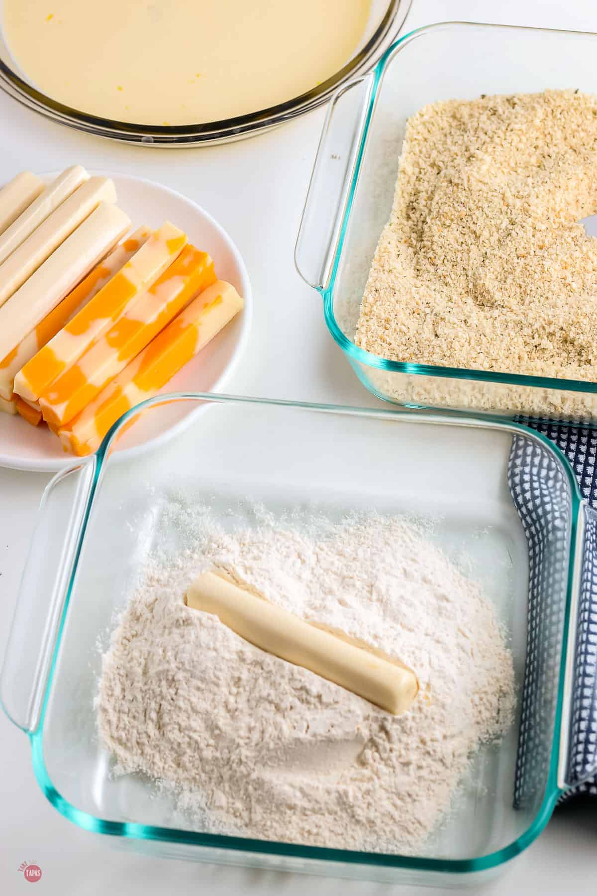 cheese stick in a glass bowl of flour