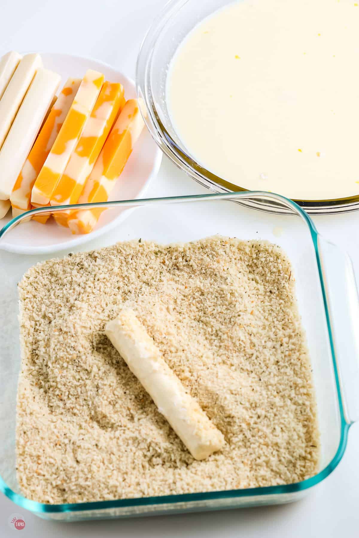 cheese stick in a bowl of panko crumbs