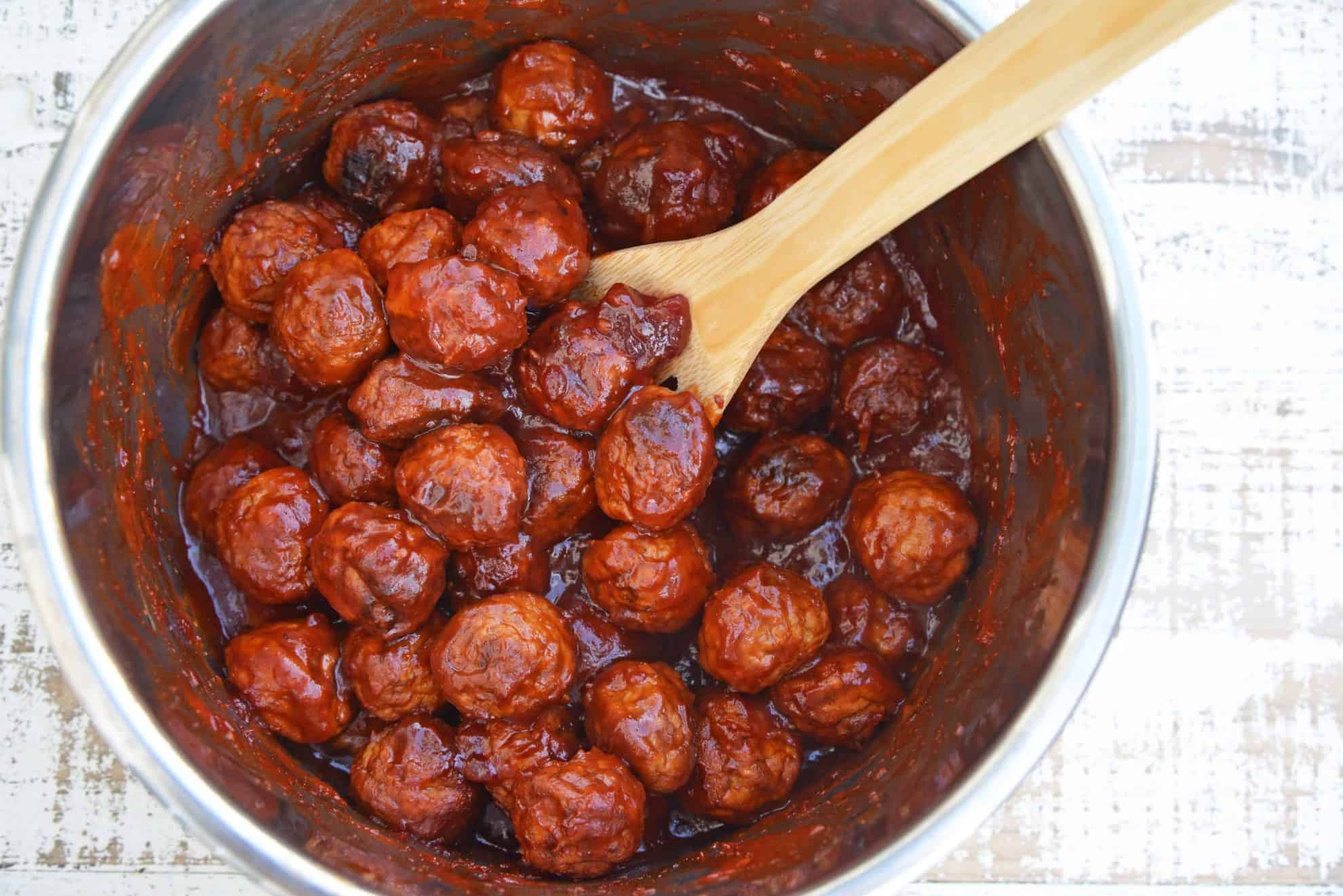 metal bowl of meatballs with wood spoon