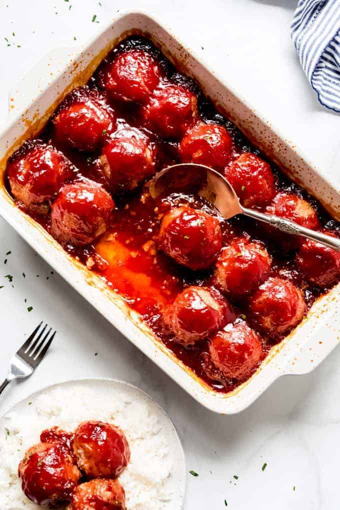 baking dish with ham balls and metal spoon