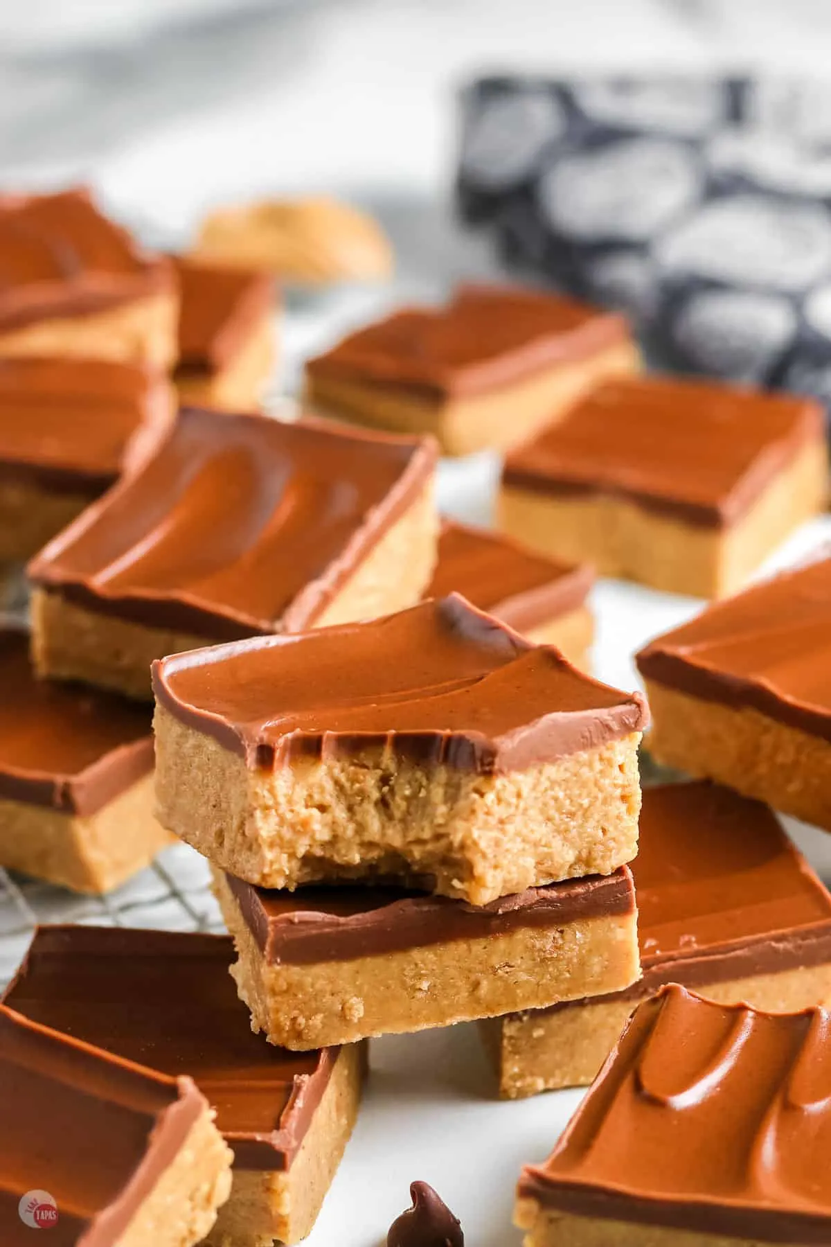 two peanut butter bars stacked on a tray of them