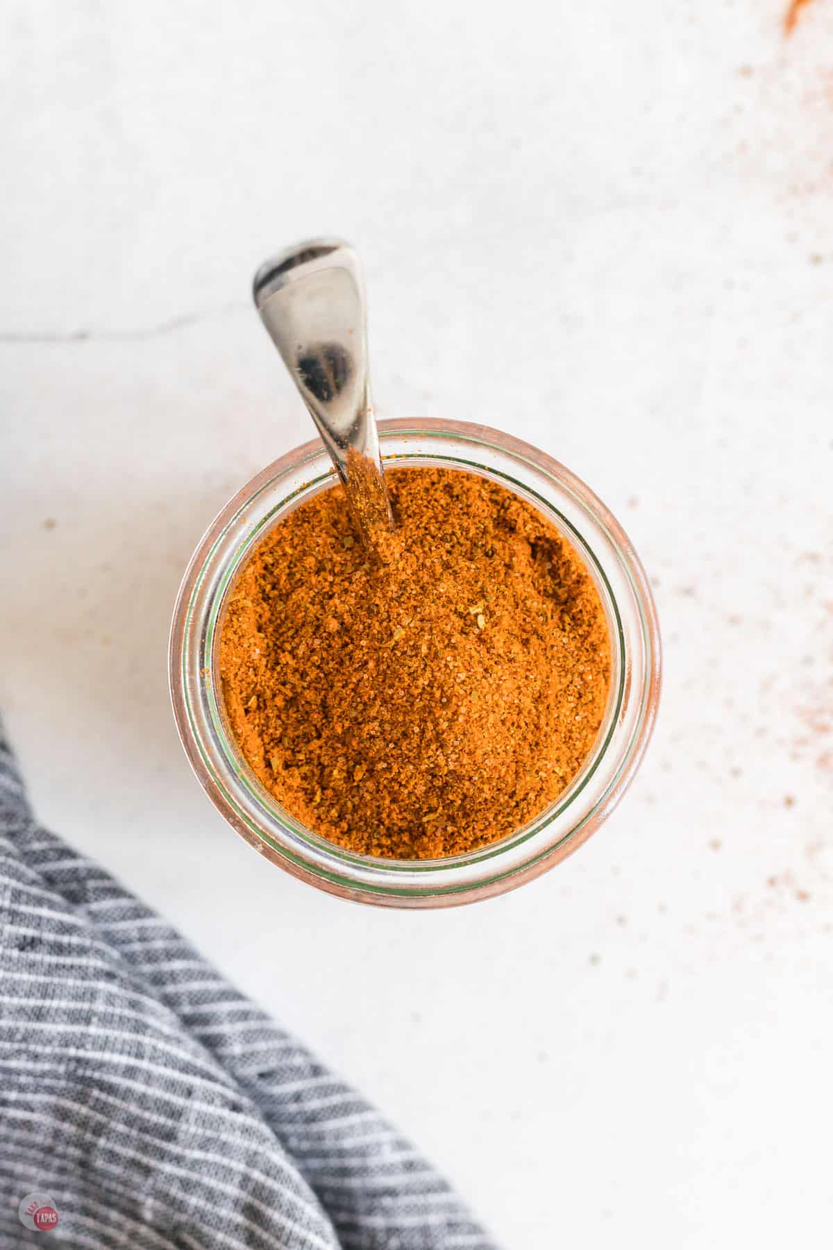 jar of old bay seasoning with a spoon