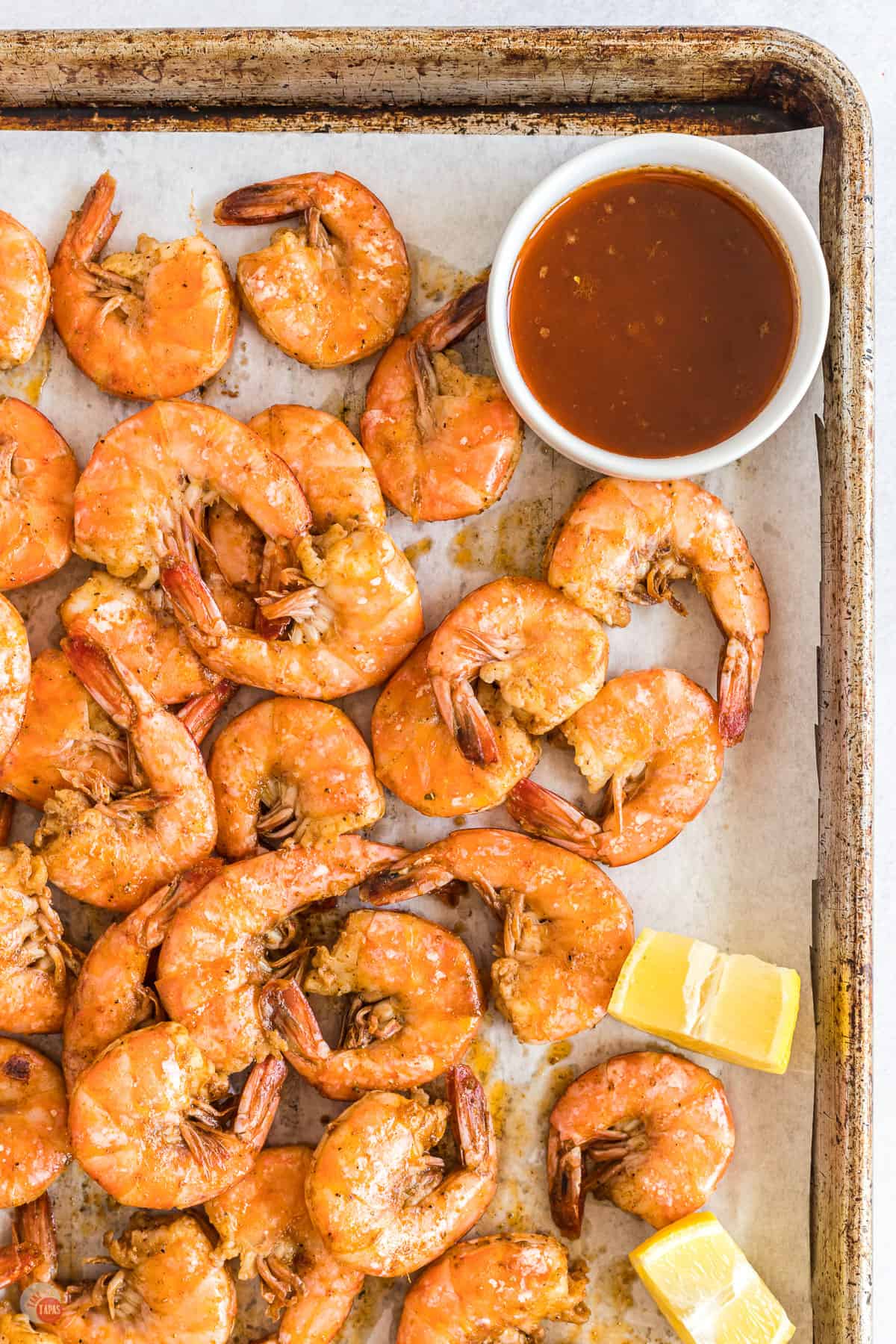 sheet pan of shrimp with bowl of spiced butter
