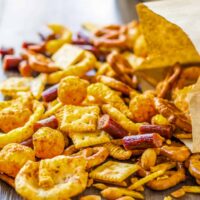 snack mix pouring out of a brown paper bag