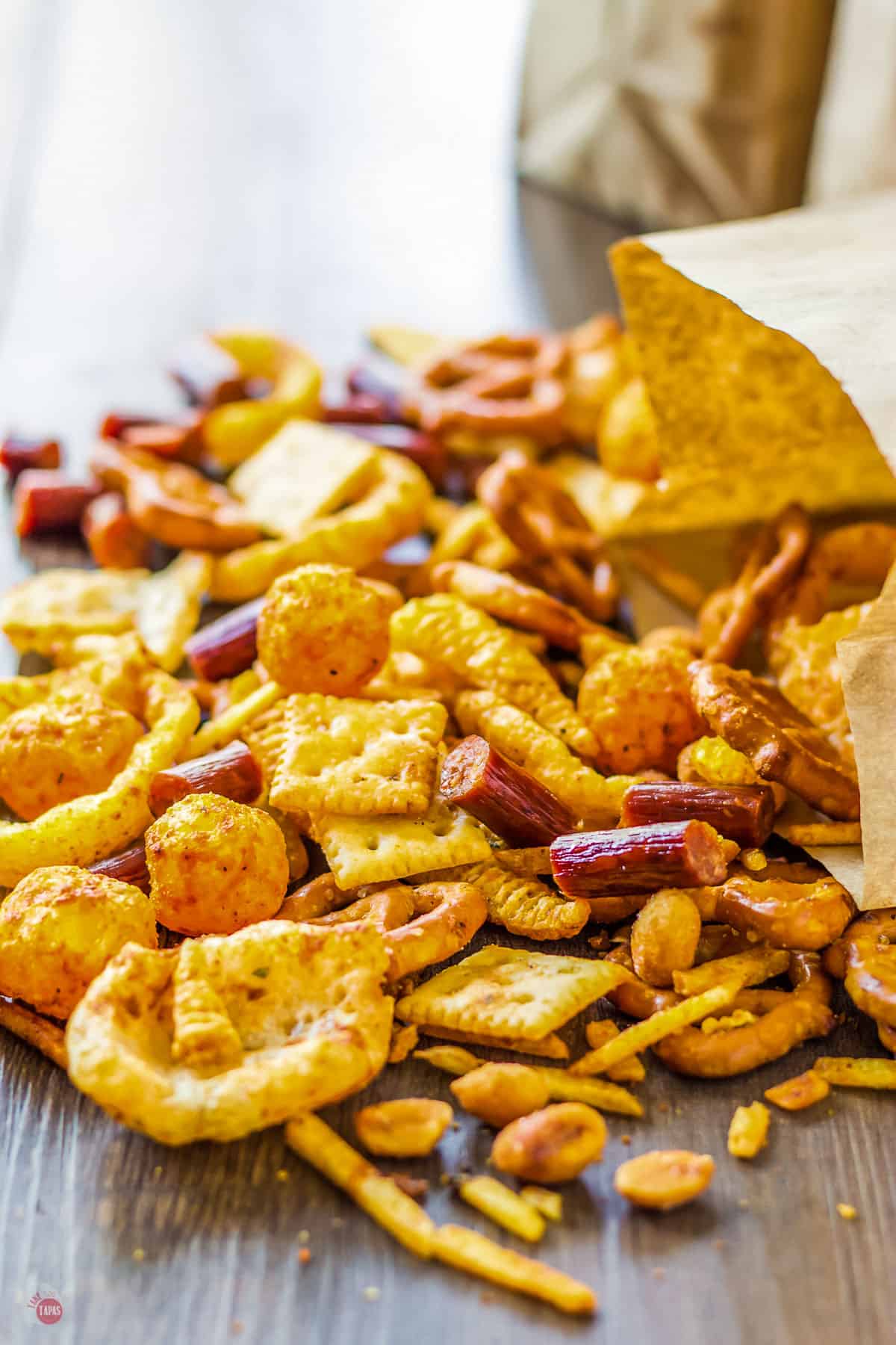 snack mix pouring out of a brown paper bag