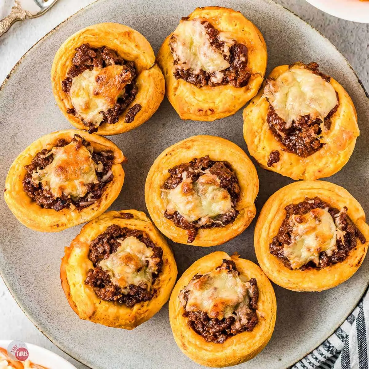 A white plate filled with sloppy joe cups.