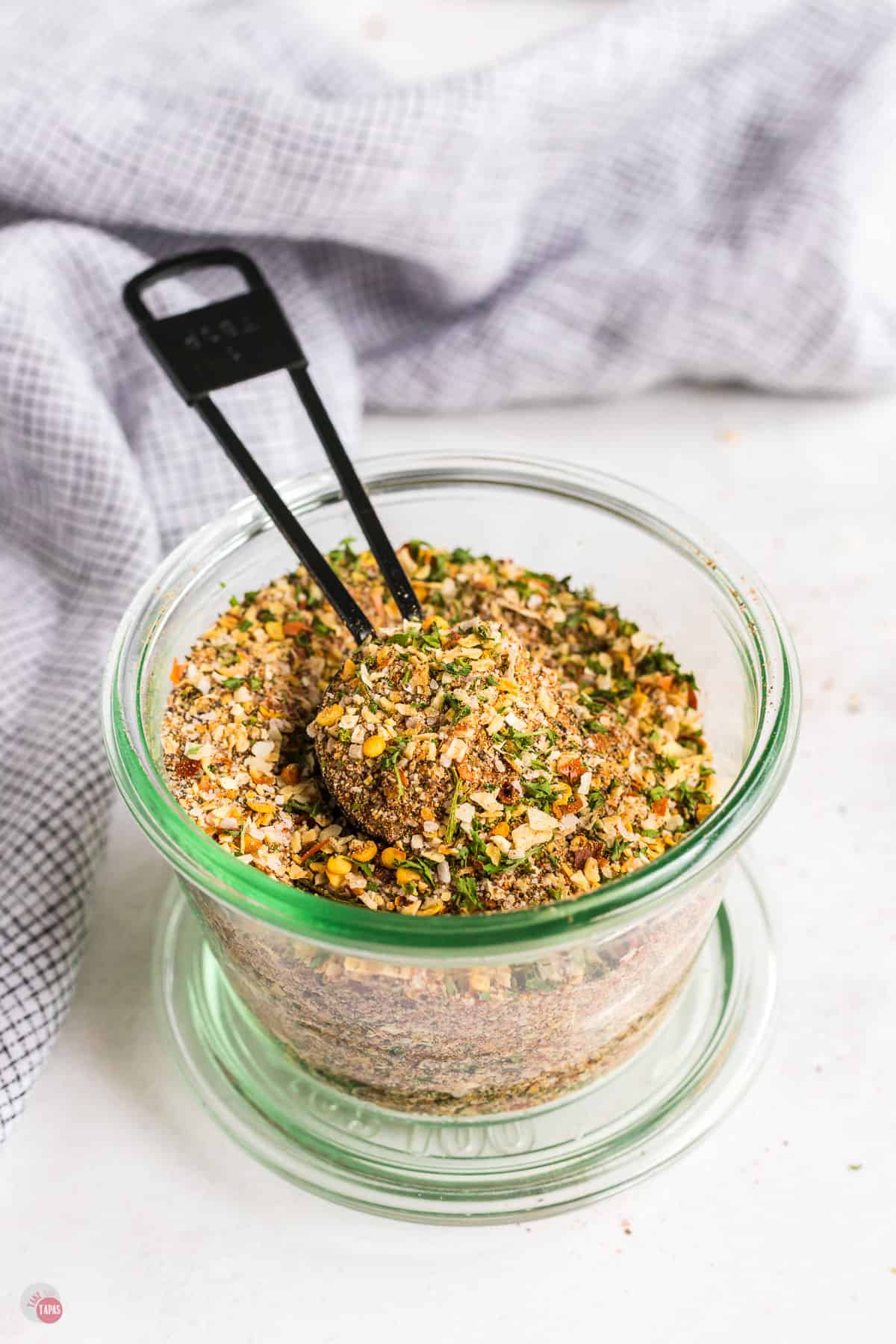 steak seasoning in a jar with a black metal spoon