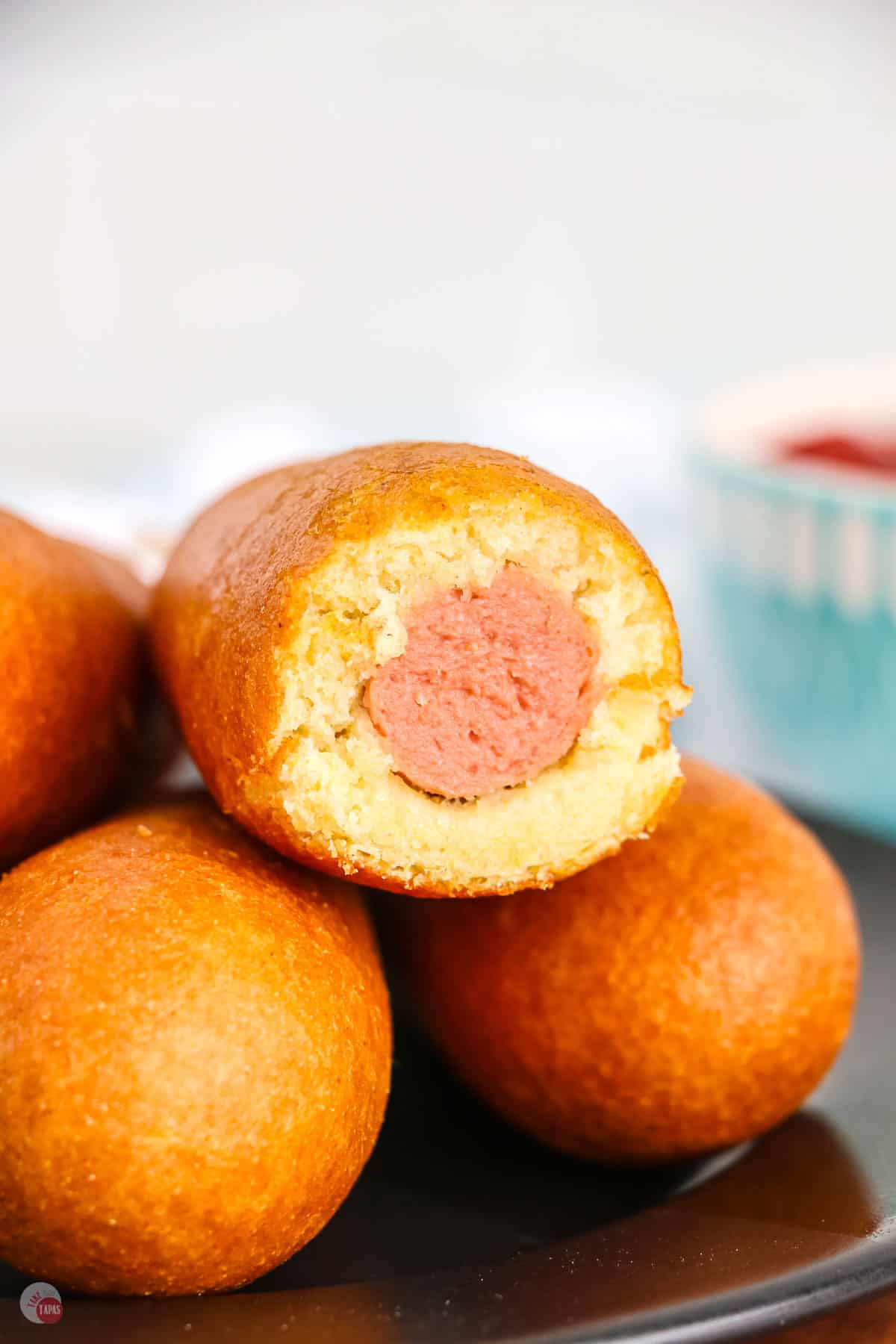 stack of corn dogs with a bite taken out of the top one