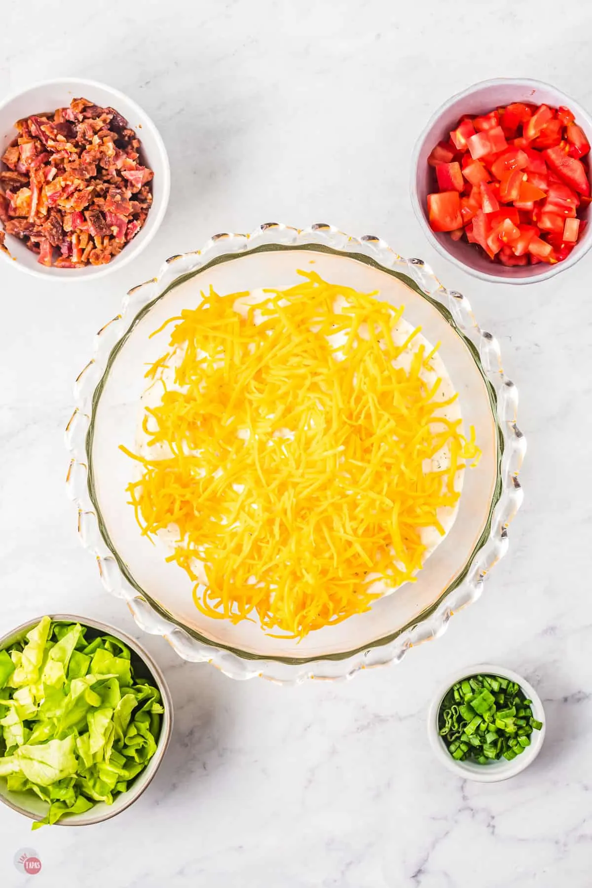 cheese in a bowl with small bowl of lettuce