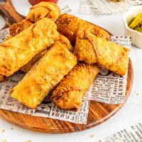 pile of egg rolls on a wood board