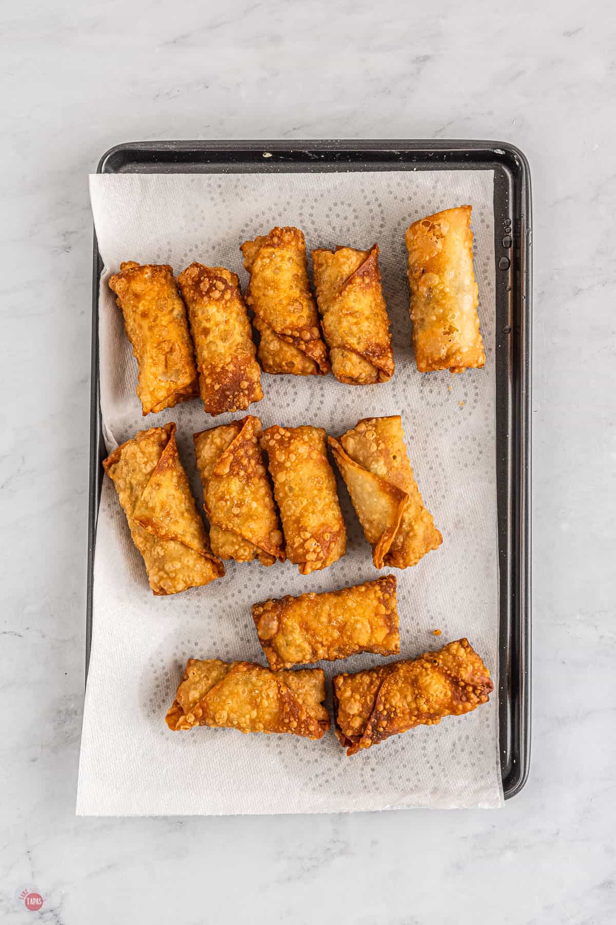 fried egg rolls on a baking sheet with parchment paper