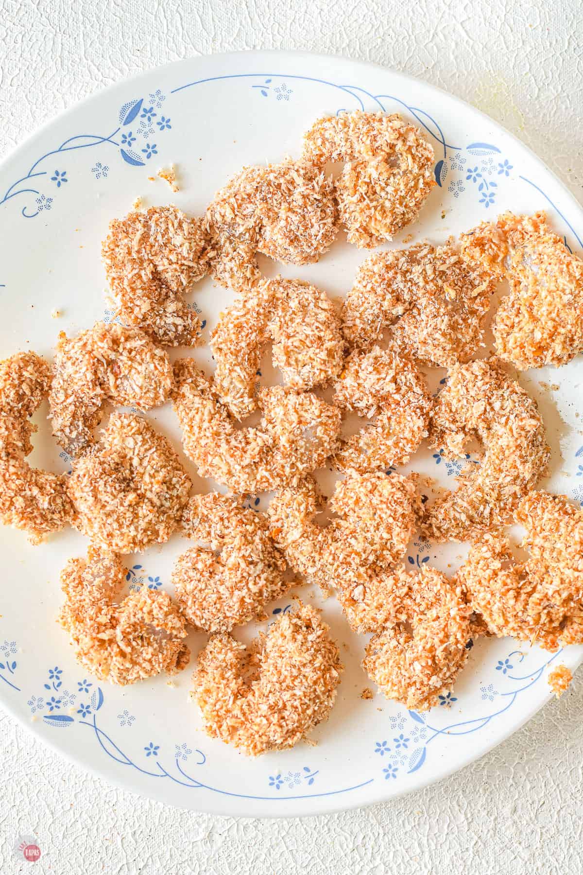 breaded shrimp on a white plate with blue trim