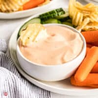 bowl of spicy dip with carrots and potato chips