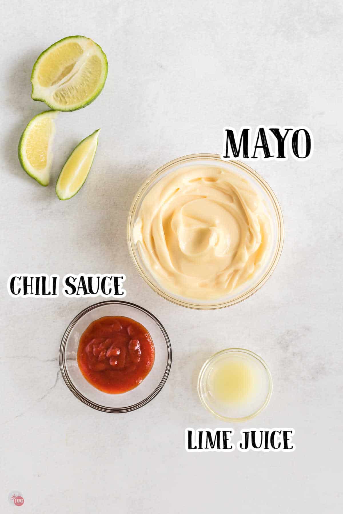 Small bowls on a worktop filled with mayo, chili sauce and lime juice with text labels next to them.