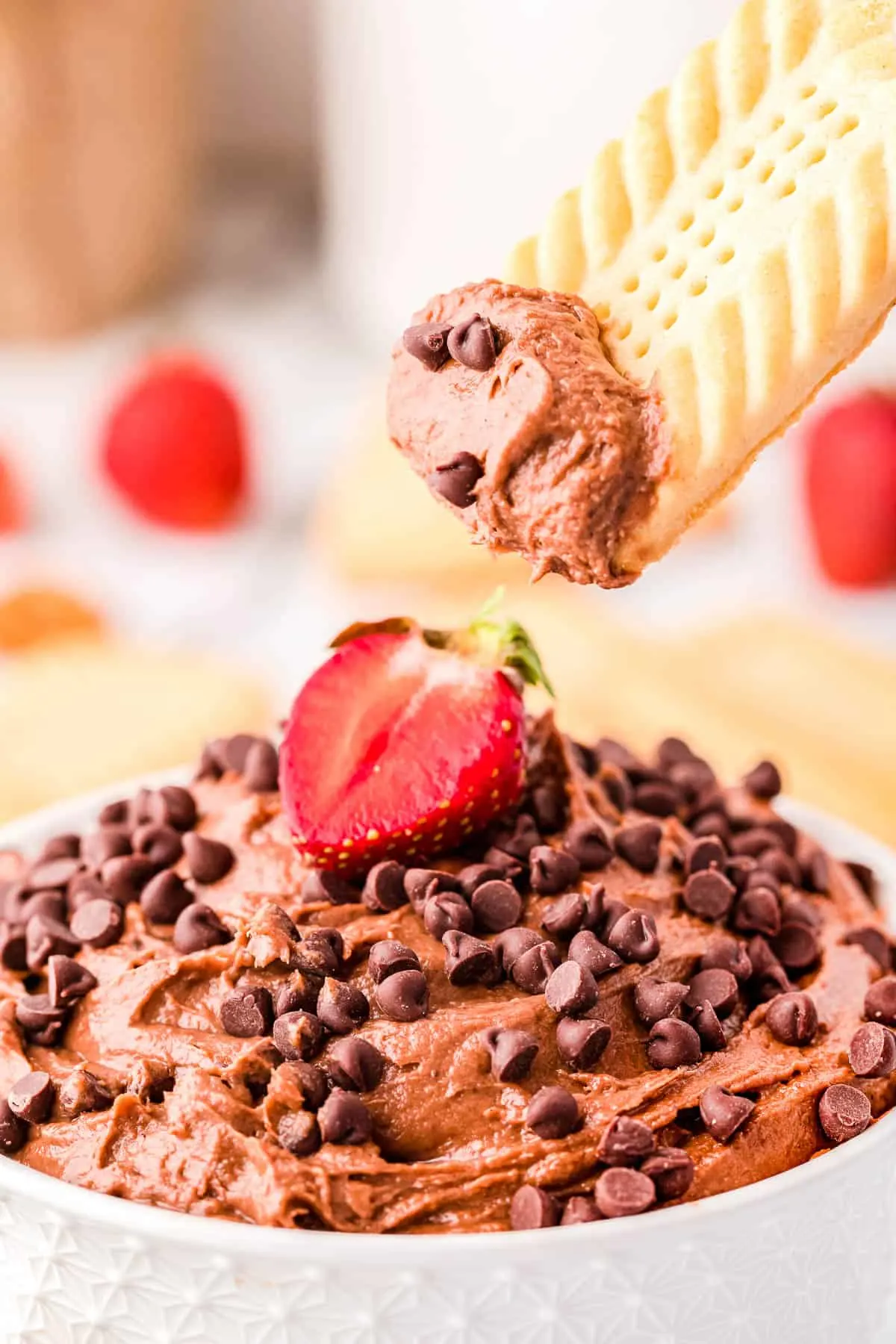 bowl of dip with chocolate chips and a cookie