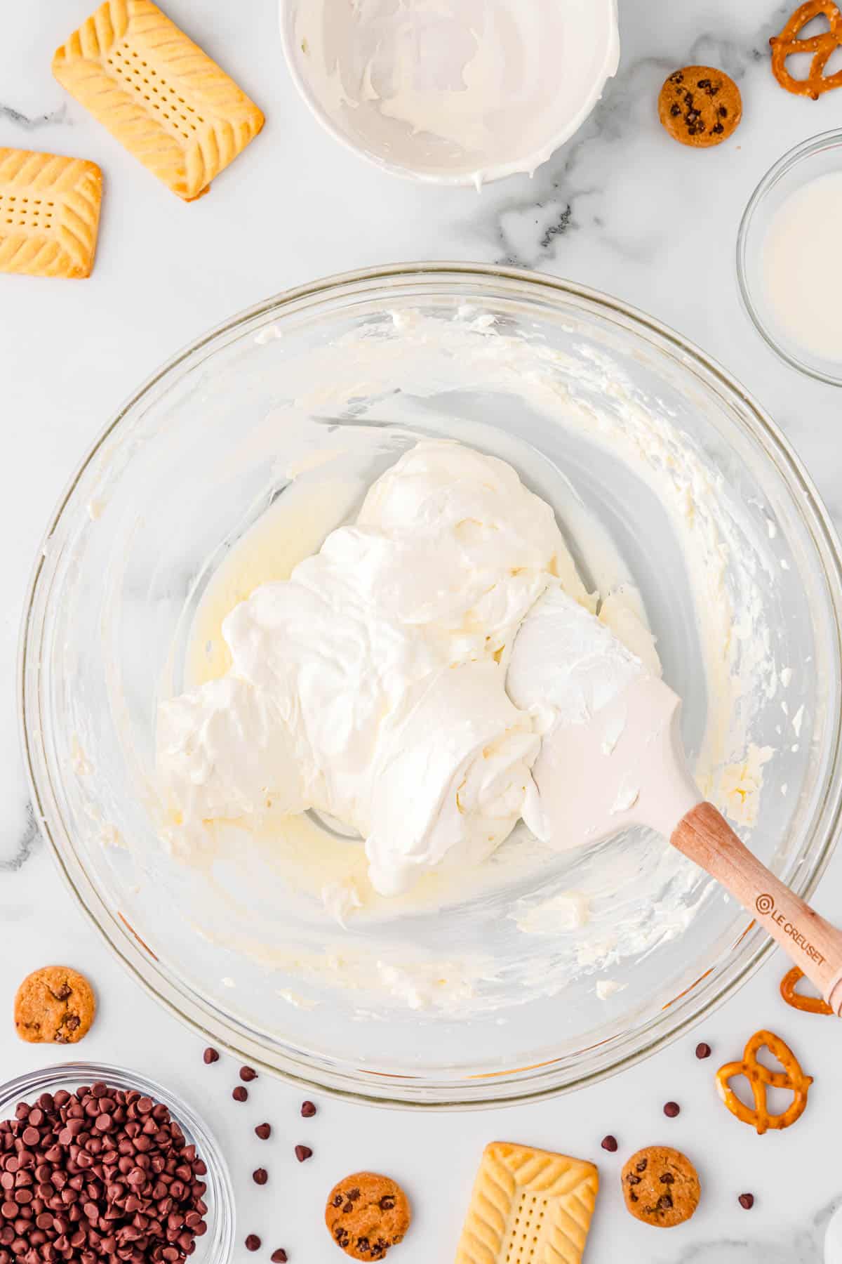 cream cheese and cool whip in a bowl with a spatula