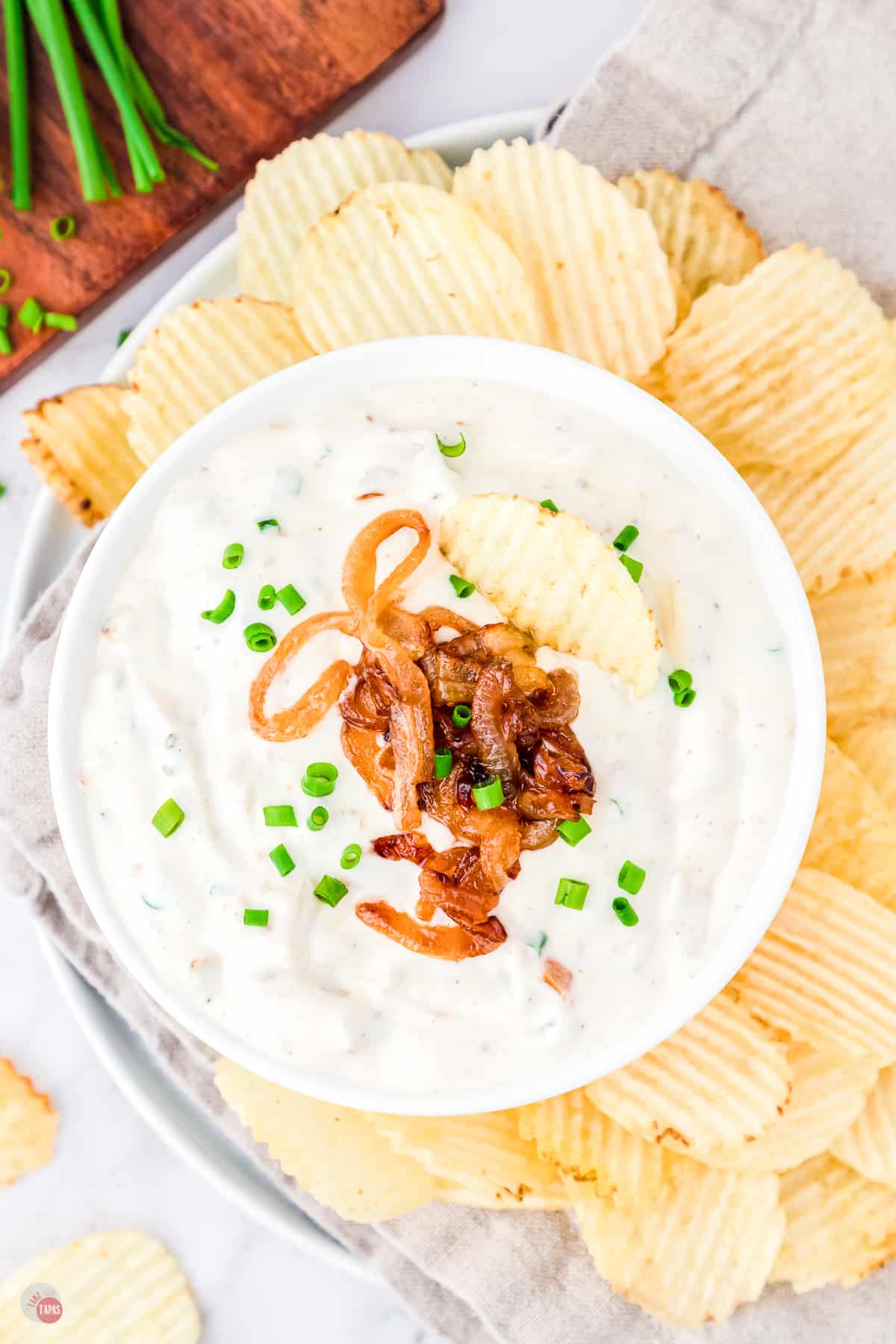bowl of dip surrounded by potato chips