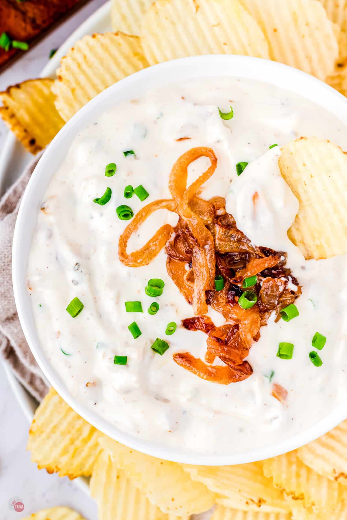 crinkle cut potato chips around a bowl of dip