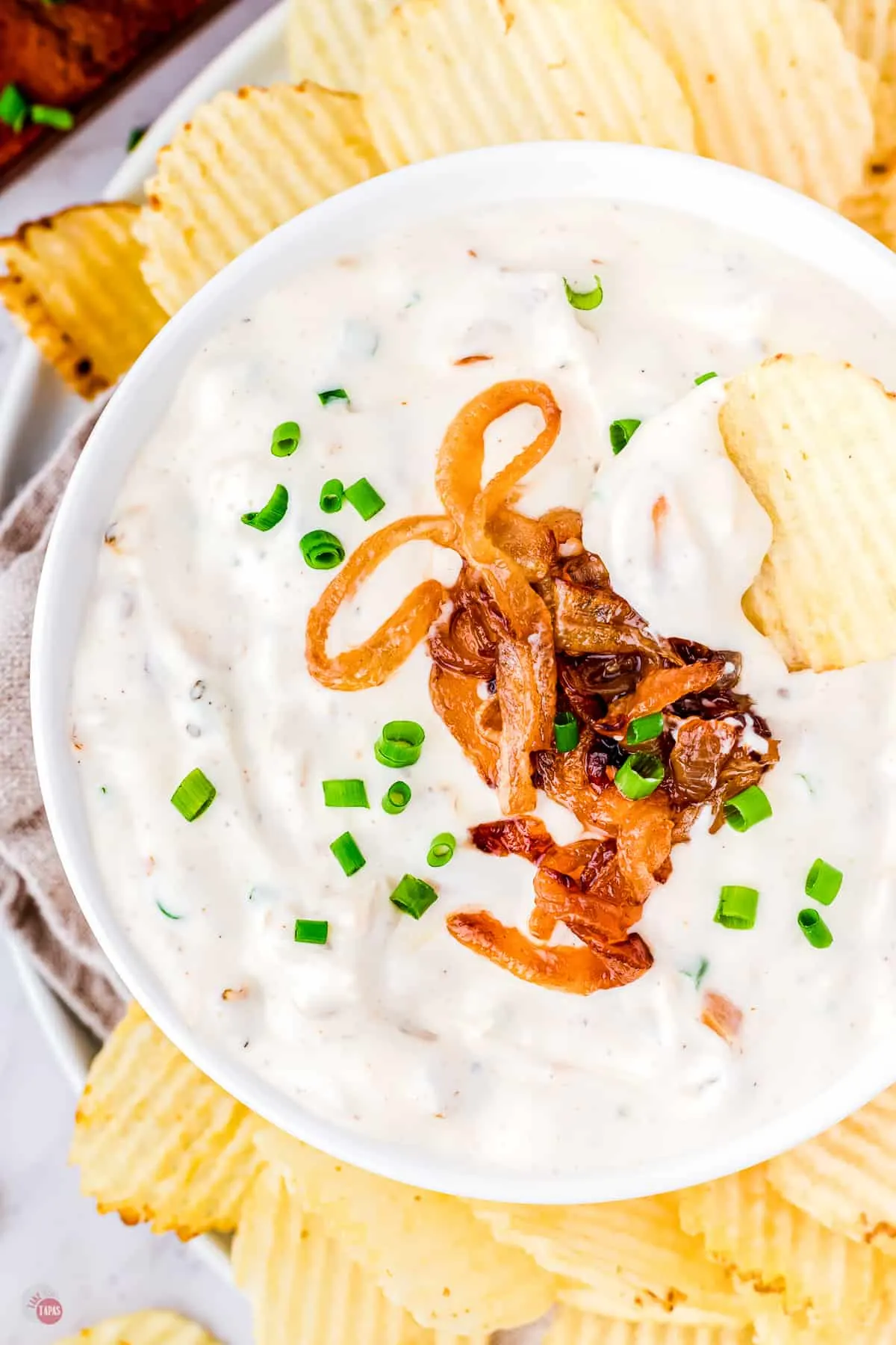 crinkle cut potato chips around a bowl of dip