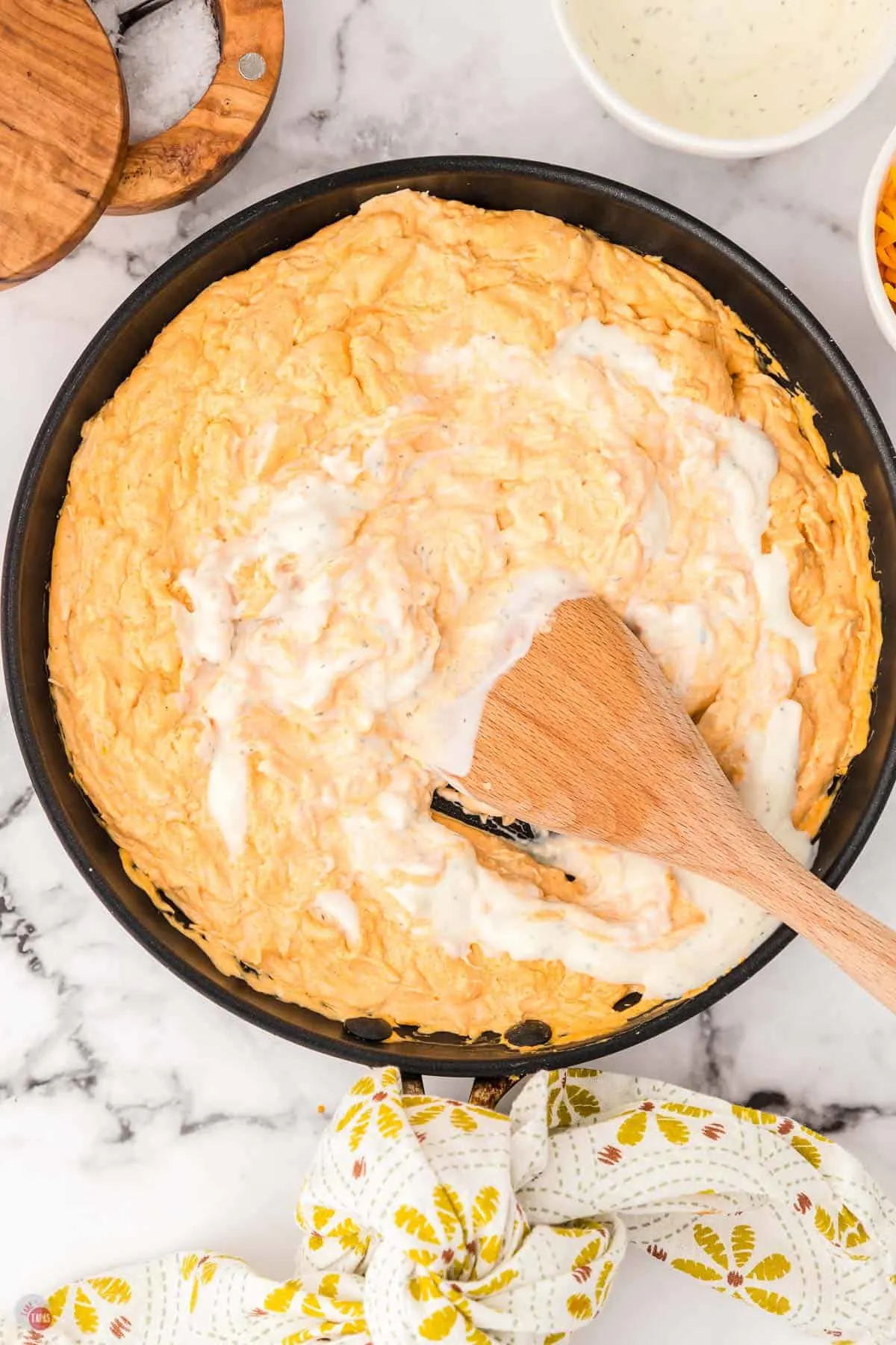 skillet with wood spoon stirring chicken and ranch dressing