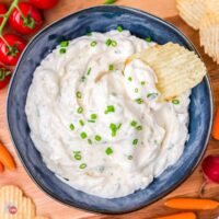 blue bowl of dip with a chip sticking out of it