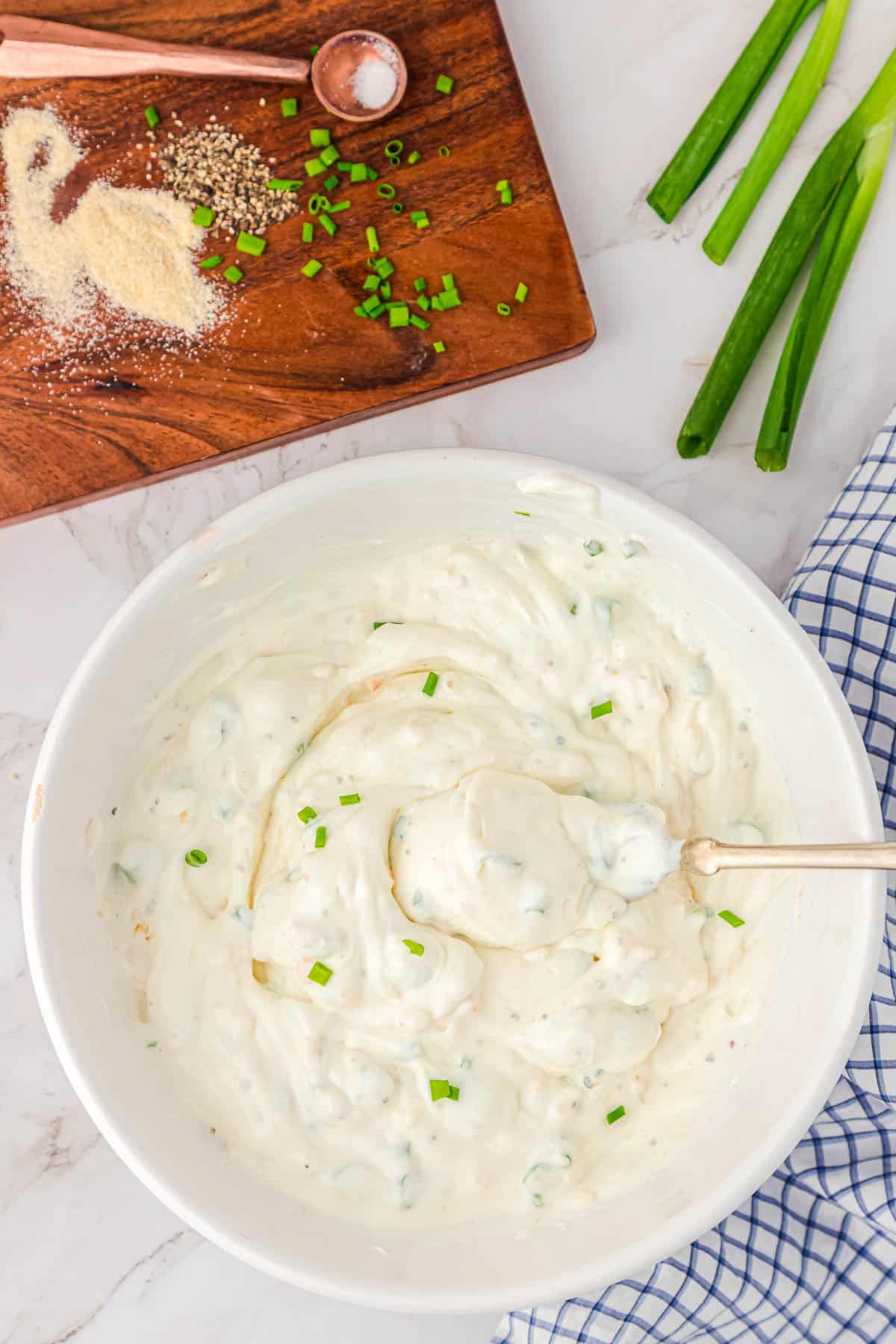 mixing sour cream and onion dip in a bowl with a spoon