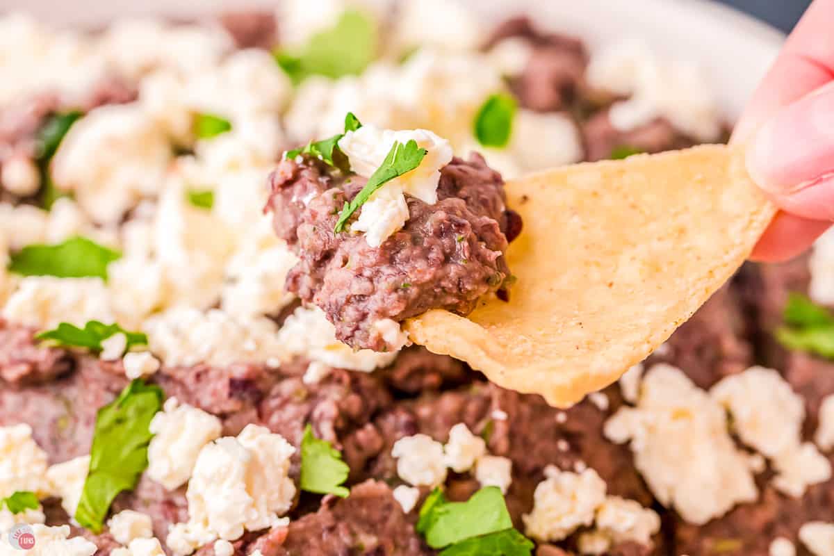 tortilla chip scooping out some black bean dip