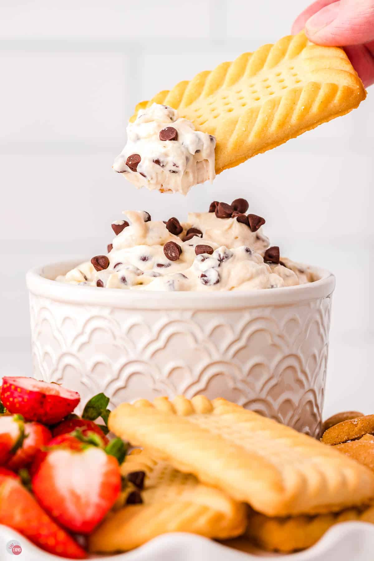 shortbread cookie dipping in a bowl of Booty Dip