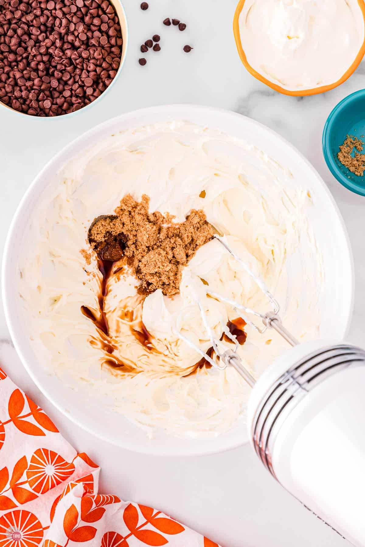 cream cheese and brown sugar in a white bowl with mixer