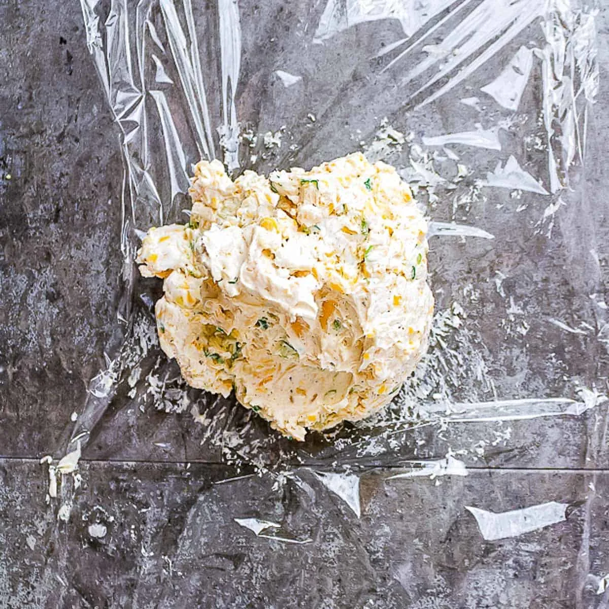 ball of cream cheese on piece of plastic wrap