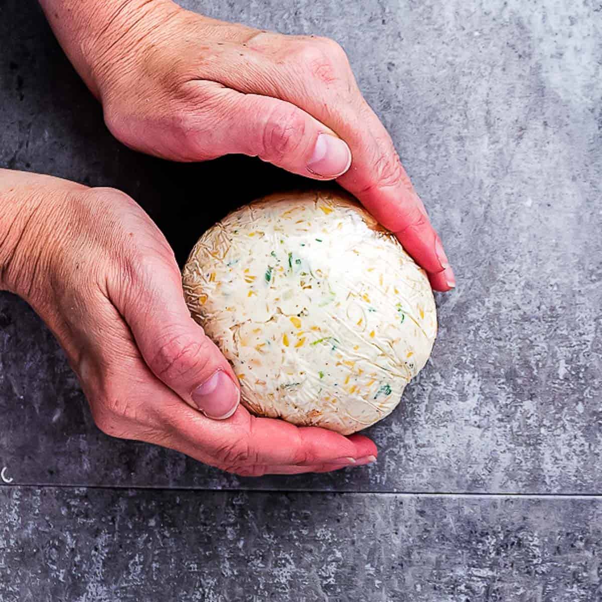 hands holding a ball wrapped in cling wrap