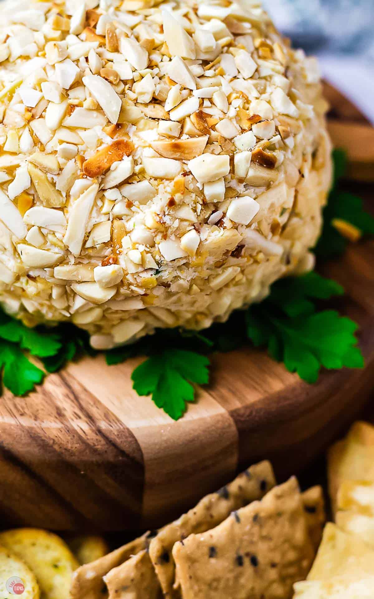 side view of cheeseball on a wood plate