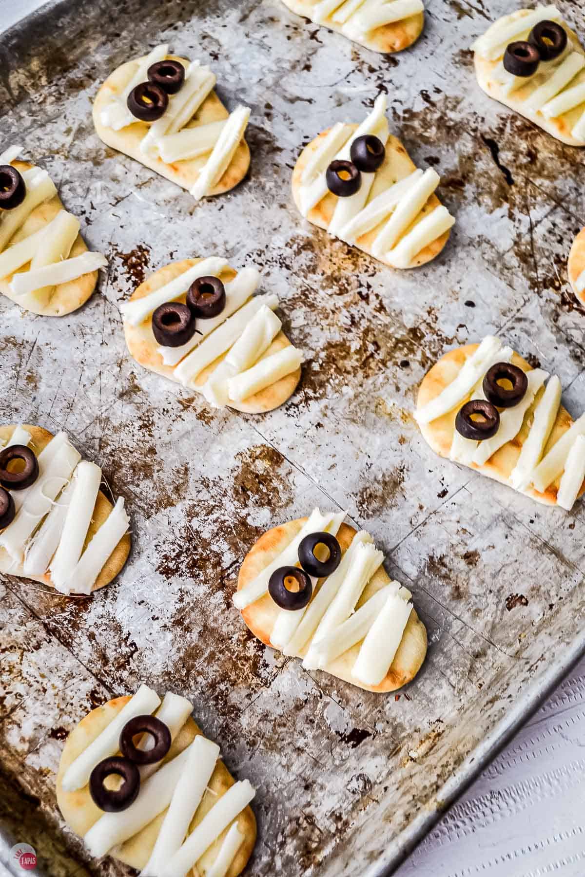 lots of tiny mummy pizzas on a baking sheet