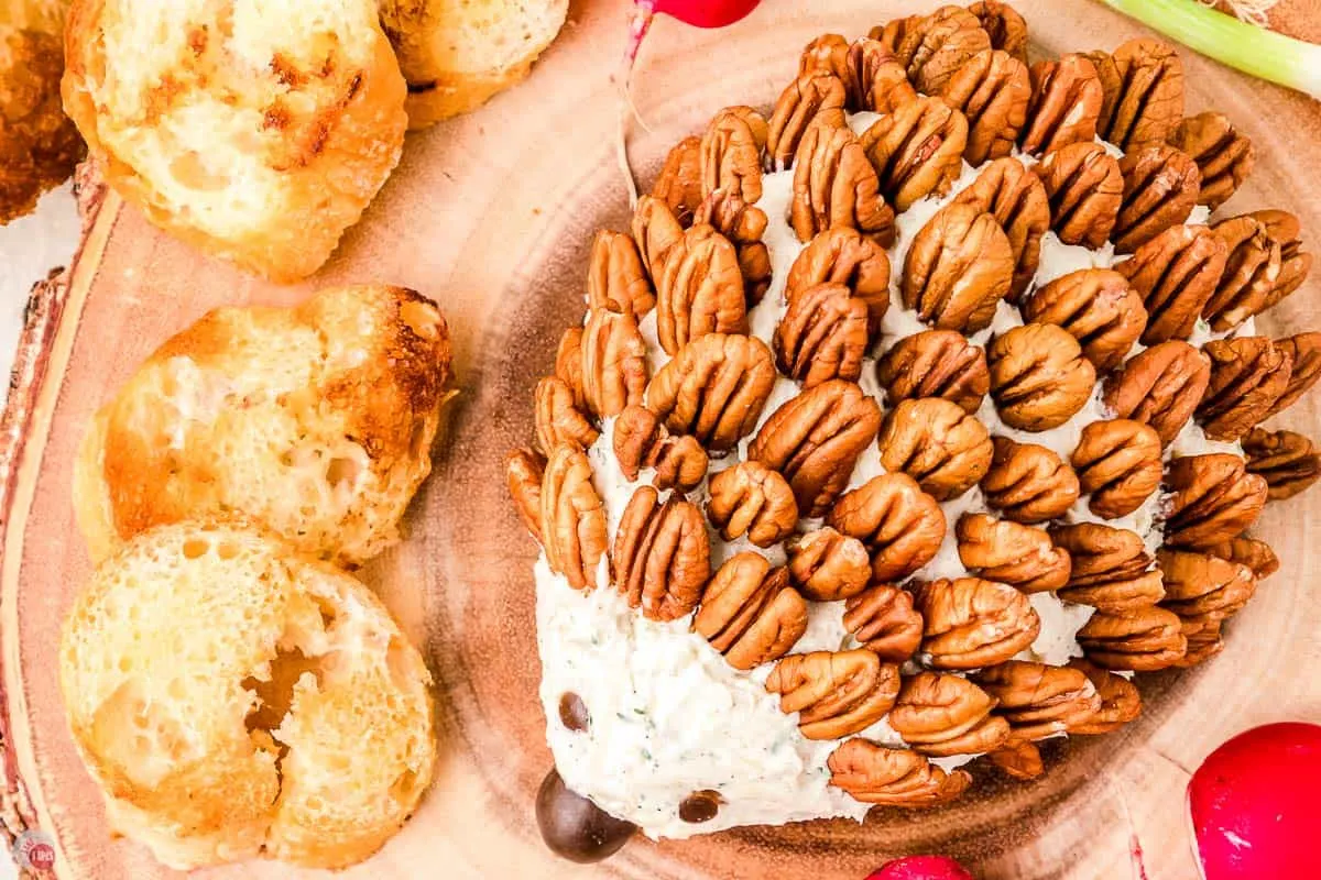 pecan halves being put into a cream cheese ball