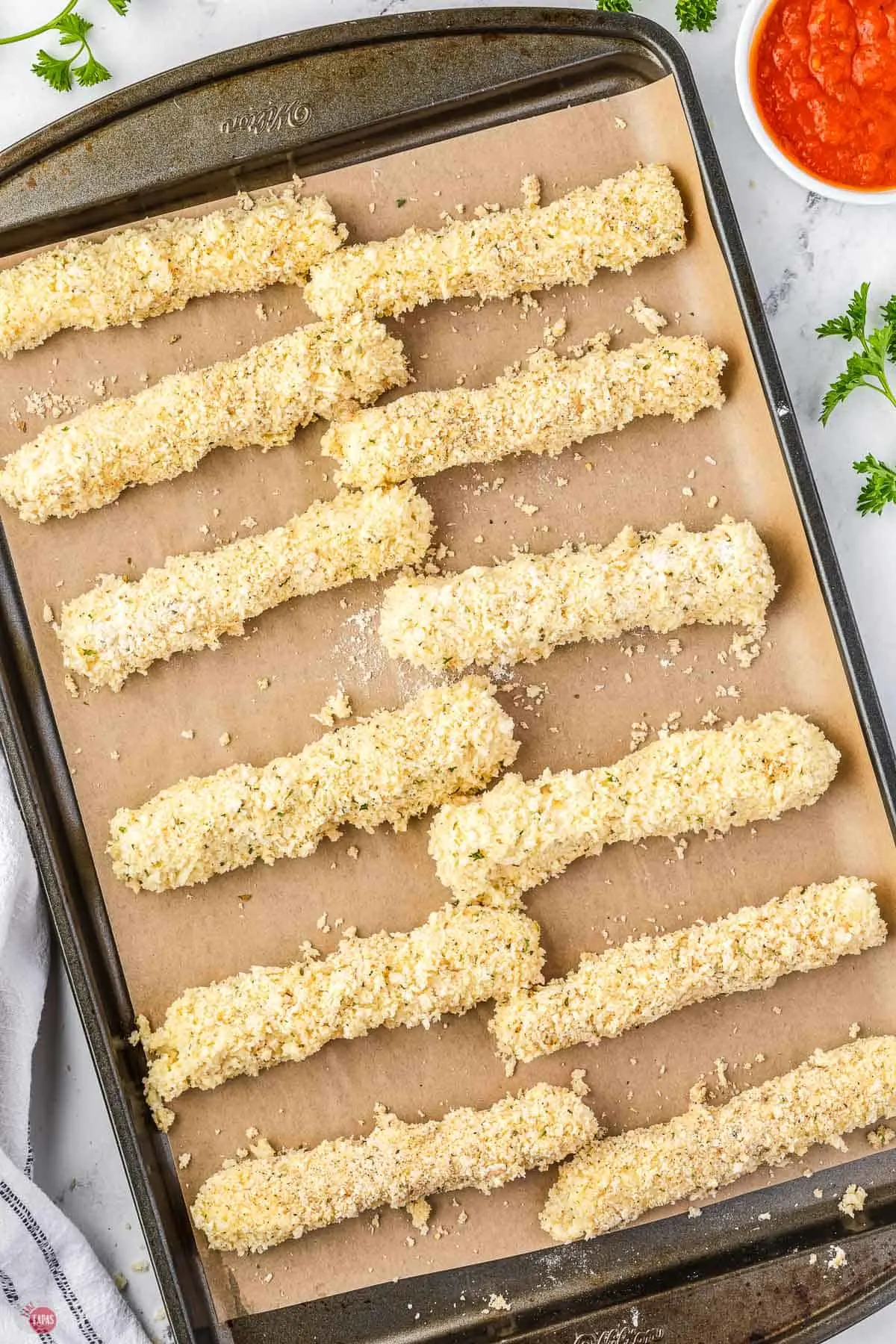 breaded cheese sticks on parchment paper