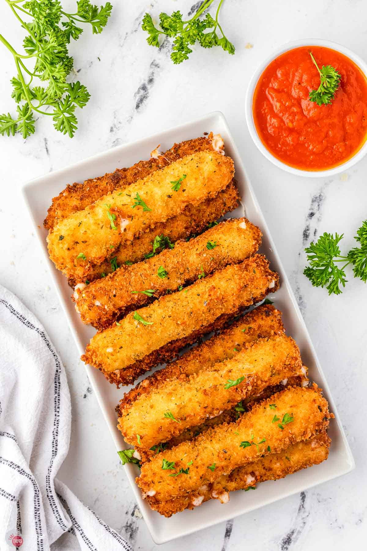 pile of cheese with one broken in half and a small bowl of red sauce