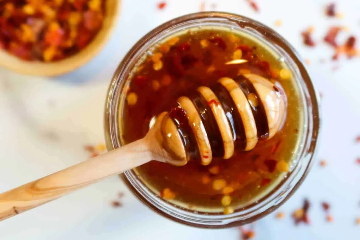 honey dipper on top of jar of hot honey