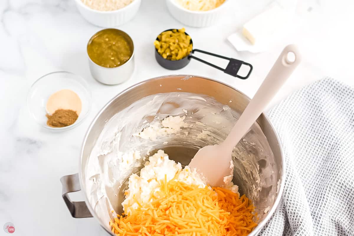 cheese and jalapenos in a mixing bowl with spatula