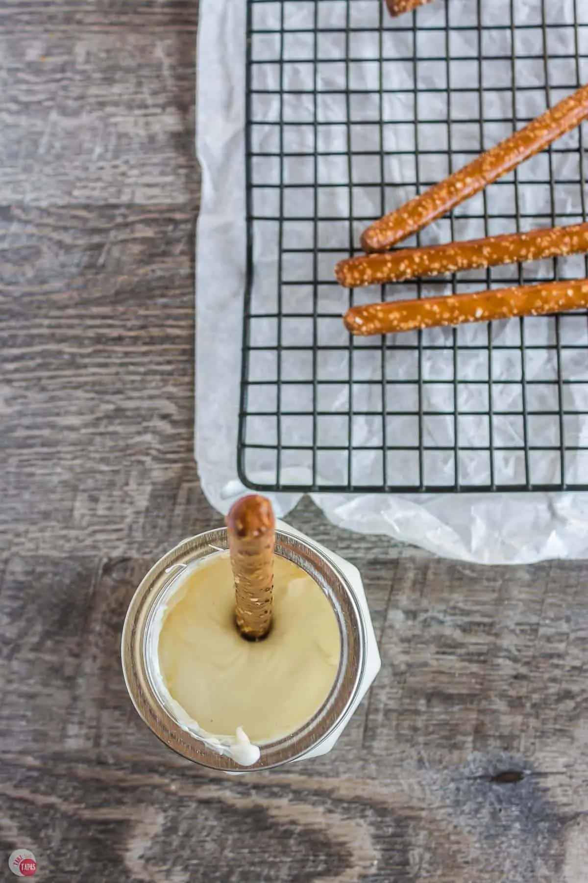 pretzel dipping in a jar of melted chocolate