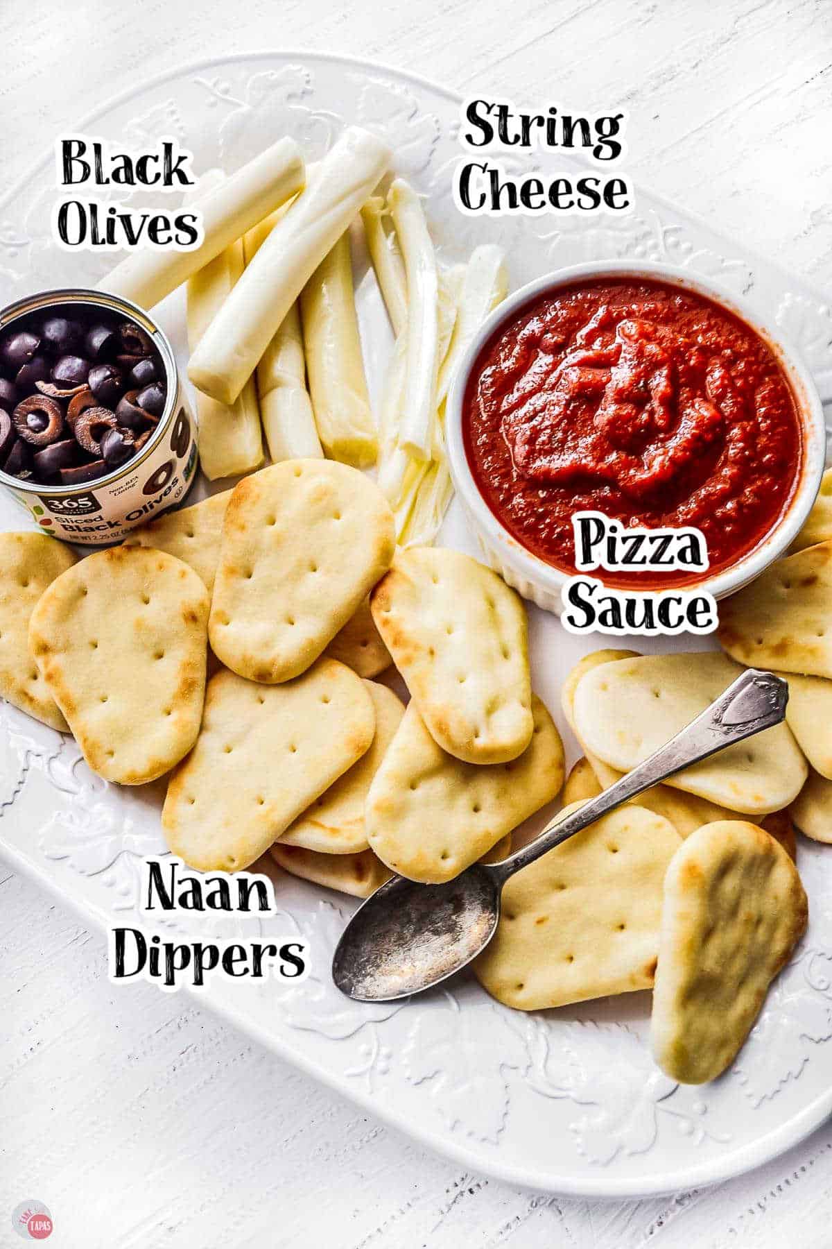 mini naan bread on a white plate with tomato sauce, olives, and cheese