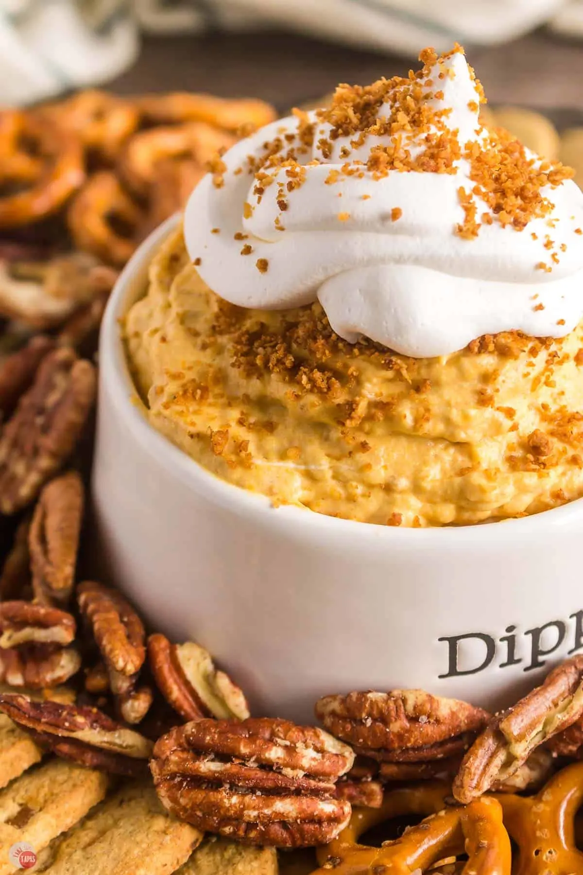 close up of pumpkin dip with pecans around it