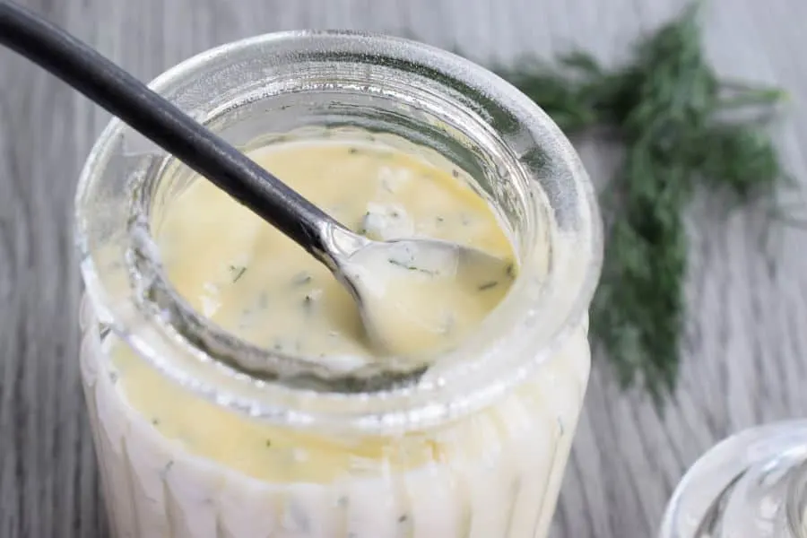 honey dill sauce in a jar with a spoon
